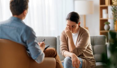 Psikolog resepsiyonundaki genç bayan hastaya danışmanlık.