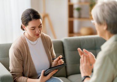 Psikolog resepsiyonundaki yaşlı kadın hastaya danışmanlık.
