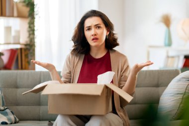 Kadın karton kutuları açıyor. Hayal kırıklığına uğramış online alışveriş kavramı.