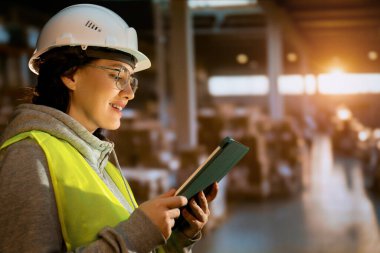 Beyaz şapkalı genç kadın depoda çalışıyor.