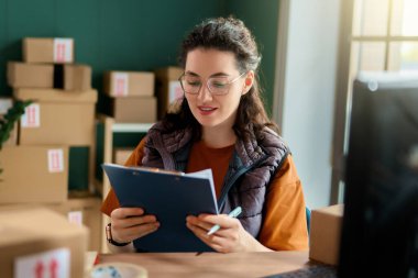 Kadın envanter müdürü stokları kontrol ediyor. Depoda çalışan bir kadın.. 