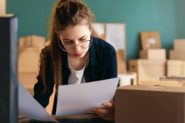 Kadın envanter müdürü stokları kontrol ediyor. Depoda çalışan bir kadın.. 