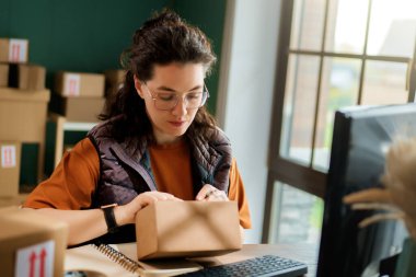 Kadın envanter müdürü stokları kontrol ediyor. Depoda çalışan bir kadın.. 