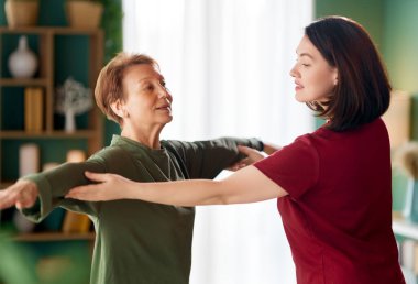 Kıdemli kadın egzersiz yapıyor. Evde fizik tedaviye yardım eden bir hemşire.