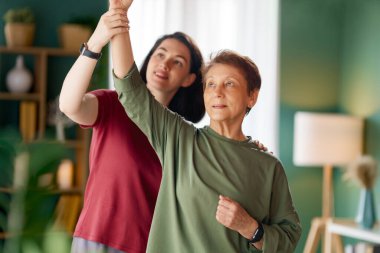 Kıdemli kadın egzersiz yapıyor. Evde fizik tedaviye yardım eden bir hemşire.