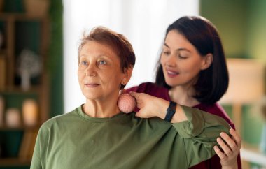 Kıdemli kadın egzersiz yapıyor. Evde fizik tedaviye yardım eden bir hemşire.