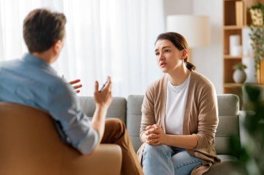 Psikolog resepsiyonundaki genç bayan hastaya danışmanlık.