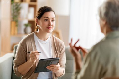 Psikolog resepsiyonundaki yaşlı kadın hastaya danışmanlık.