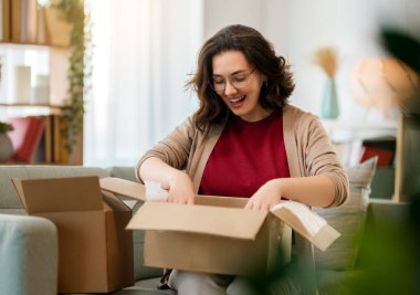 Kadın karton kutuları açıyor. Çevrimiçi alışveriş kavramı.