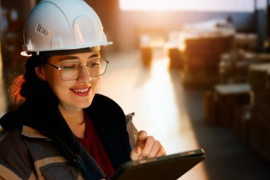 Beyaz şapkalı genç kadın depoda çalışıyor.