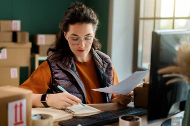 Kadın envanter müdürü stokları kontrol ediyor. Depoda çalışan bir kadın.. 