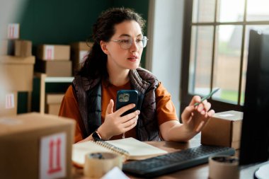 Kadın envanter müdürü stokları kontrol ediyor. Depoda çalışan bir kadın.. 