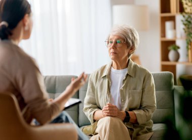 Psikolog resepsiyonundaki yaşlı kadın hastaya danışmanlık.