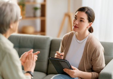 Psikolog resepsiyonundaki yaşlı kadın hastaya danışmanlık.