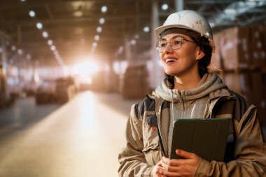 Beyaz şapkalı genç kadın depoda çalışıyor.