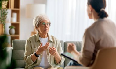 Psikolog resepsiyonundaki yaşlı kadın hastaya danışmanlık.
