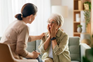 Psikolog resepsiyonundaki yaşlı kadın hastaya danışmanlık.