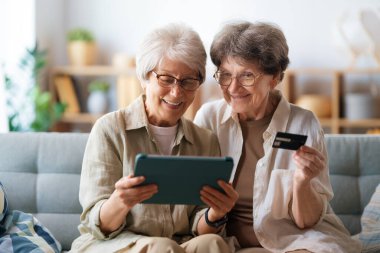 Kadınlar internetten alışveriş yapıyor. Üst sınıflar evde laptop ve kredi kartı kullanarak alışveriş yapıyorlar..