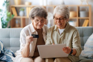 Kadınlar internetten alışveriş yapıyor. Üst sınıflar evde laptop ve kredi kartı kullanarak alışveriş yapıyorlar..