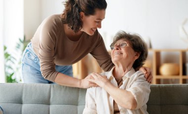 Mutlu hasta ve bakıcı birlikte vakit geçiriyor. Büyük kadın ve yetişkin kızı..