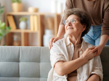 Mutlu hasta ve bakıcı birlikte vakit geçiriyor. Büyük kadın ve yetişkin kızı..