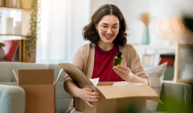 Kadın karton kutuları açıyor. Çevrimiçi alışveriş kavramı.