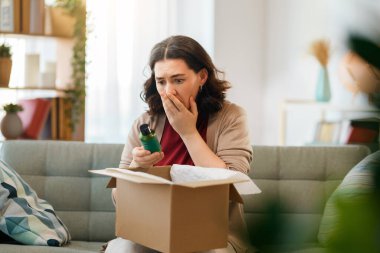 Kadın karton kutuları açıyor. Hayal kırıklığına uğramış online alışveriş kavramı.
