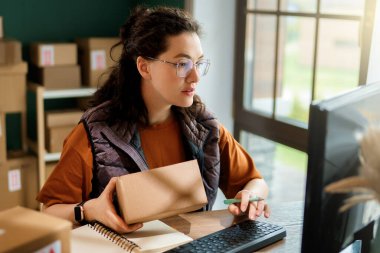 Kadın envanter müdürü stokları kontrol ediyor. Depoda çalışan bir kadın.. 