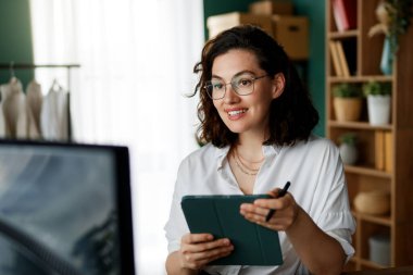 Genç kadın moda tasarımcısı stüdyoda çalışıyor..