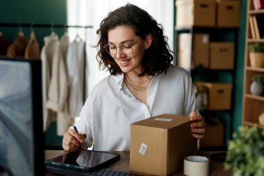 Genç kadın moda tasarımcısı stüdyoda çalışıyor..