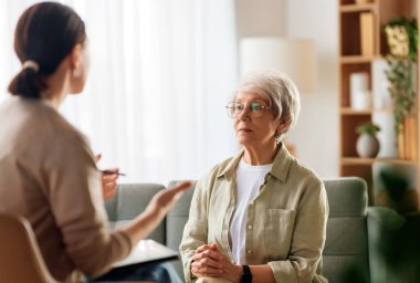 Psikolog resepsiyonundaki yaşlı kadın hastaya danışmanlık.