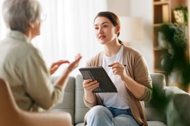 Psikolog resepsiyonundaki yaşlı kadın hastaya danışmanlık.