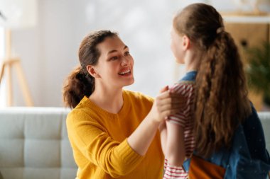 Mutlu aile okula hazırlanıyor. Annesi olan küçük bir kız..