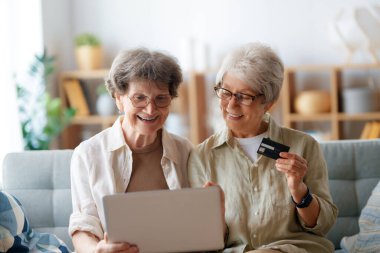 Kadınlar internetten alışveriş yapıyor. Üst sınıflar evde laptop ve kredi kartı kullanarak alışveriş yapıyorlar..