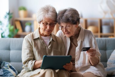 Kadınlar internetten alışveriş yapıyor. Üst sınıflar evde laptop ve kredi kartı kullanarak alışveriş yapıyorlar..