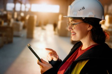 Beyaz şapkalı genç kadın depoda çalışıyor.