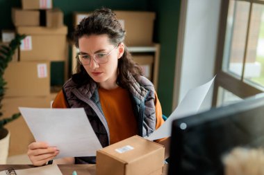 Kadın envanter müdürü stokları kontrol ediyor. Depoda çalışan bir kadın.. 