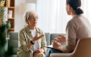 Psikolog resepsiyonundaki yaşlı kadın hastaya danışmanlık.