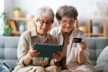 Kadınlar internetten alışveriş yapıyor. Üst sınıflar evde laptop ve kredi kartı kullanarak alışveriş yapıyorlar..