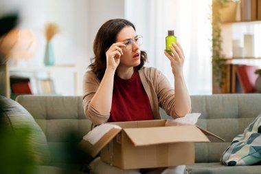 Kadın karton kutuları açıyor. Hayal kırıklığına uğramış online alışveriş kavramı.