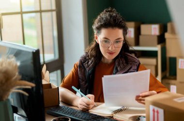 Kadın envanter müdürü stokları kontrol ediyor. Depoda çalışan bir kadın.. 