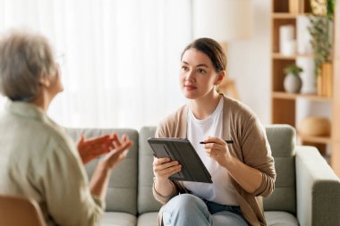 Psikolog resepsiyonundaki yaşlı kadın hastaya danışmanlık.