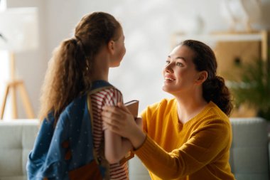 Mutlu aile okula hazırlanıyor. Annesi olan küçük bir kız..