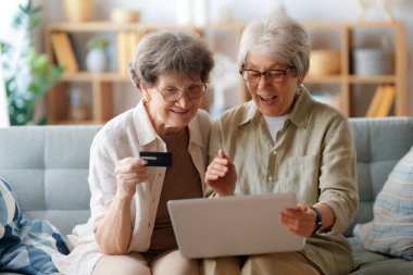 Kadınlar internetten alışveriş yapıyor. Üst sınıflar evde laptop ve kredi kartı kullanarak alışveriş yapıyorlar..