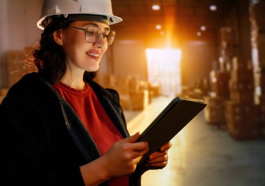 Beyaz şapkalı genç kadın depoda çalışıyor.