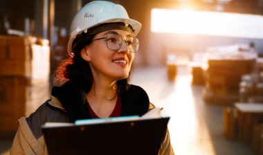 Beyaz şapkalı genç kadın depoda çalışıyor.