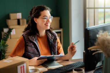 Kadın envanter müdürü stokları kontrol ediyor. Depoda çalışan bir kadın.. 