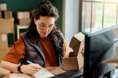 Kadın envanter müdürü stokları kontrol ediyor. Depoda çalışan bir kadın.. 