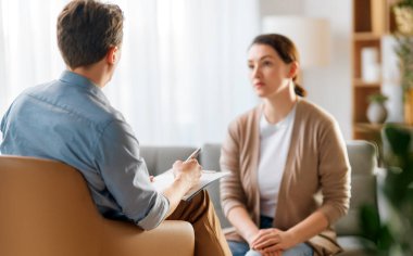 Psikolog resepsiyonundaki genç bayan hastaya danışmanlık.