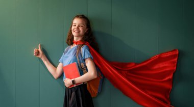 Süper kahraman bir öğrenci. Kitapları duvara dayamış bir kız öğrenci..